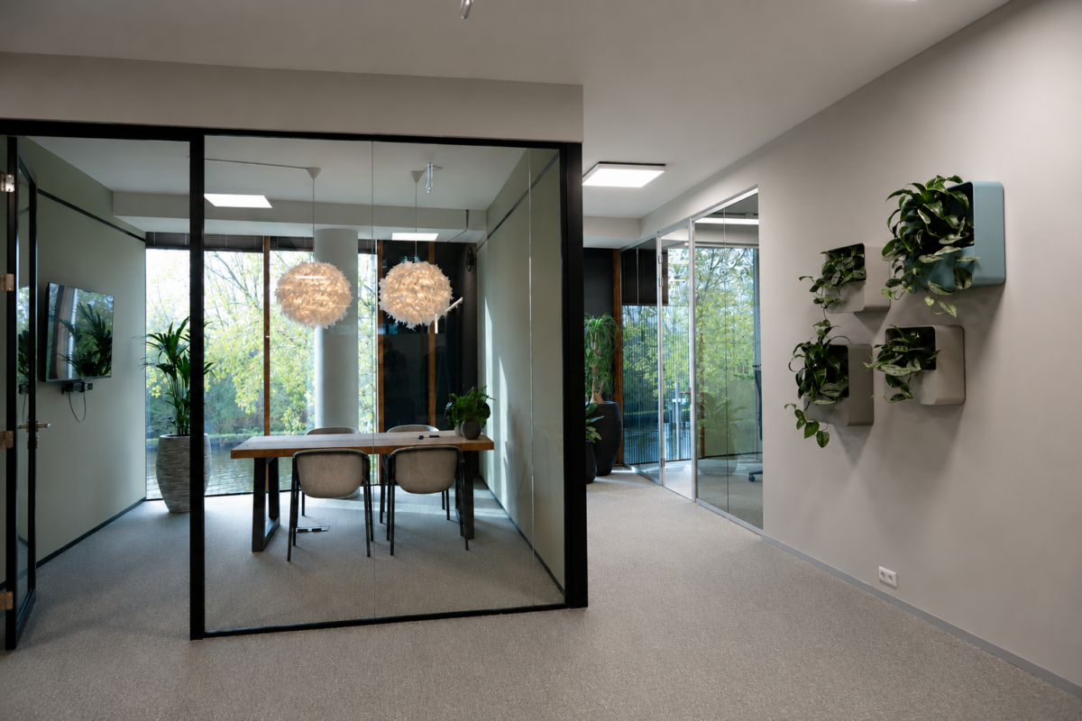 Glazen vergaderkamer met natuurlijke materialen en planten als onderdeel van een modern zakelijk interieur voor ChaletsPlus.