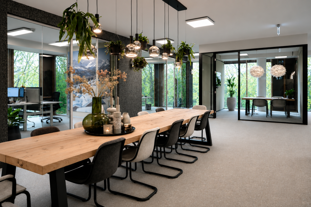 Complete kantoorinrichting voor ChaletsPlus met ruime vergadertafel, glazen kantoorruimtes, planten en een warme uitstraling geïnspireerd op Oostenrijk.