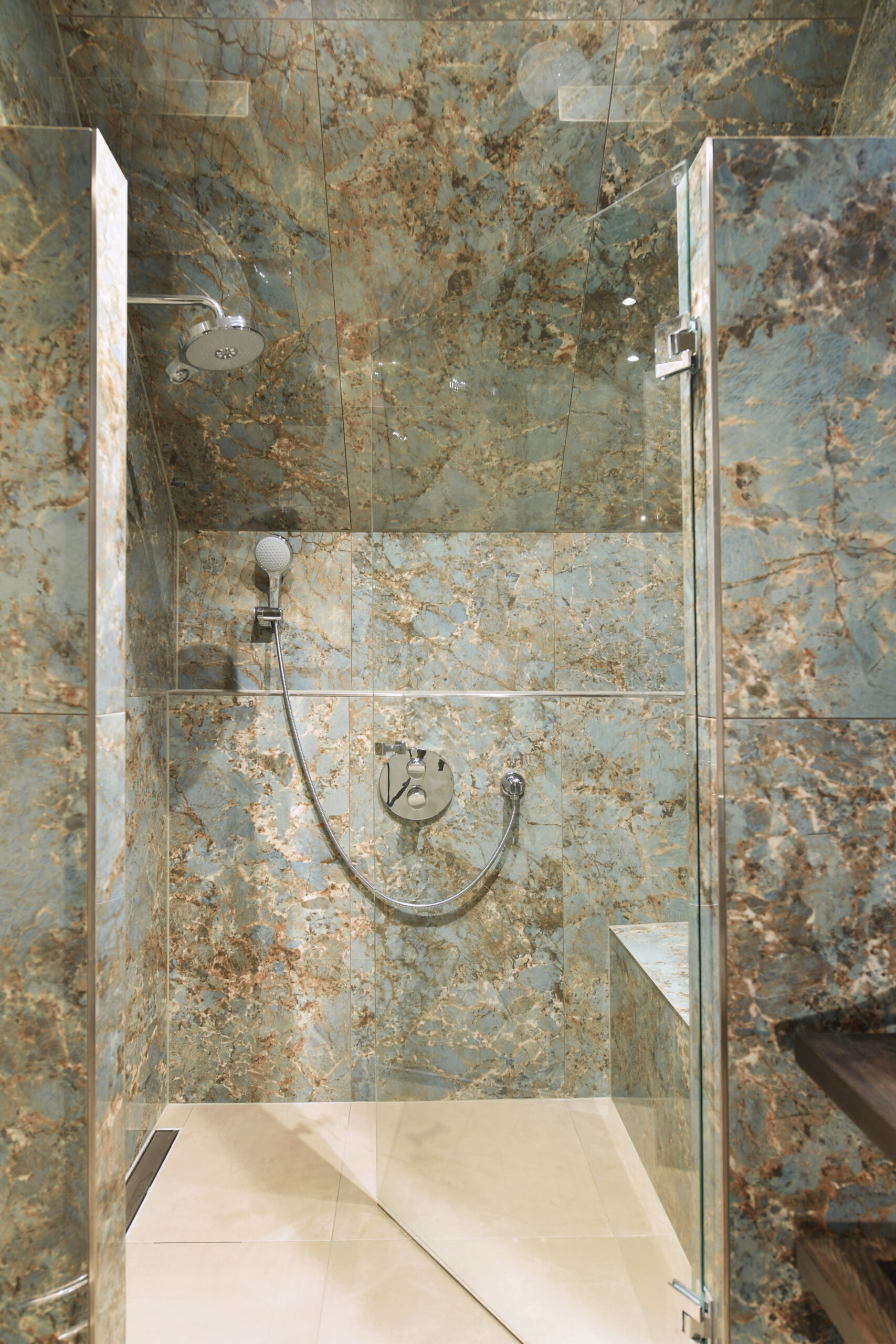 Luxe inloopdouche met opvallende natuursteenlook tegels en hoogwaardige afwerking
