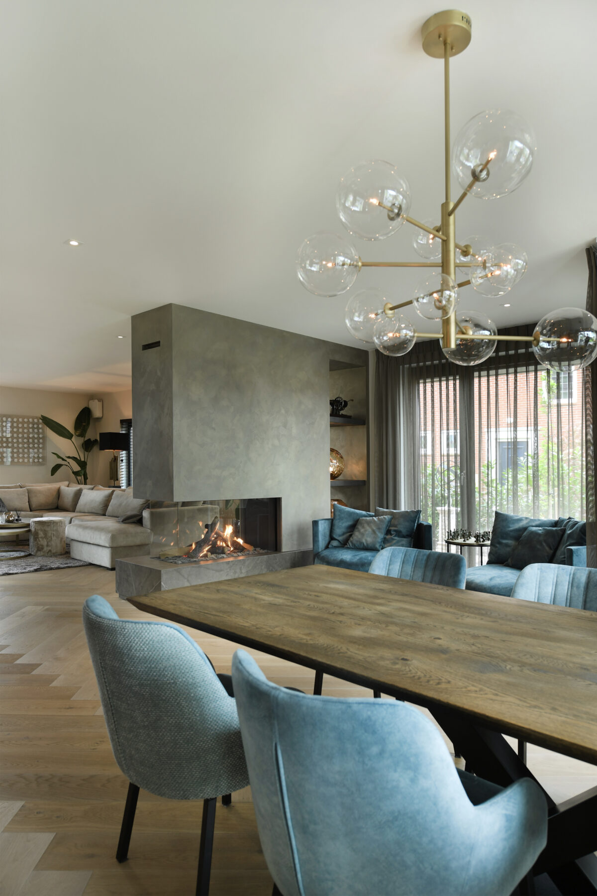 Hotel chique eetkamer met design hanglamp, houten eettafel en moderne gashaard