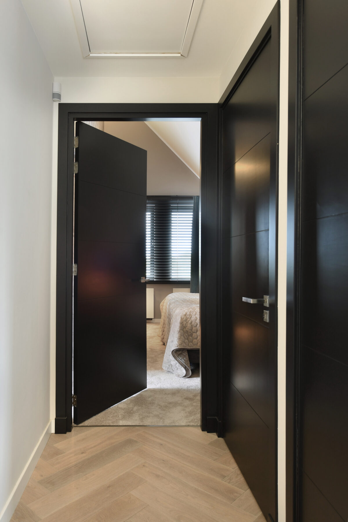 Doorkijk vanuit de hal naar de hotel chique master bedroom in een onder architectuur gebouwde villa