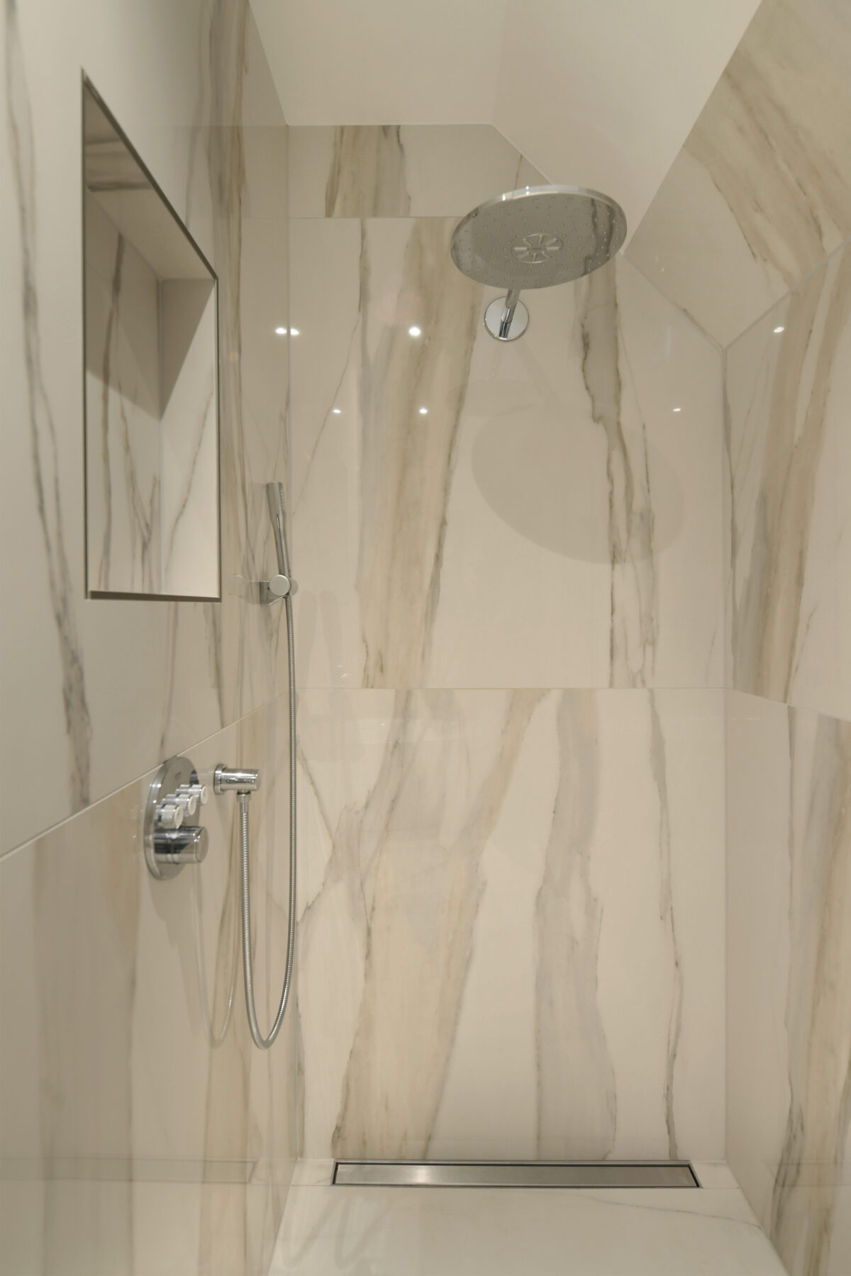 Royale inloopdouche met regendouche en marmerlook wandtegels in een luxe badkamer