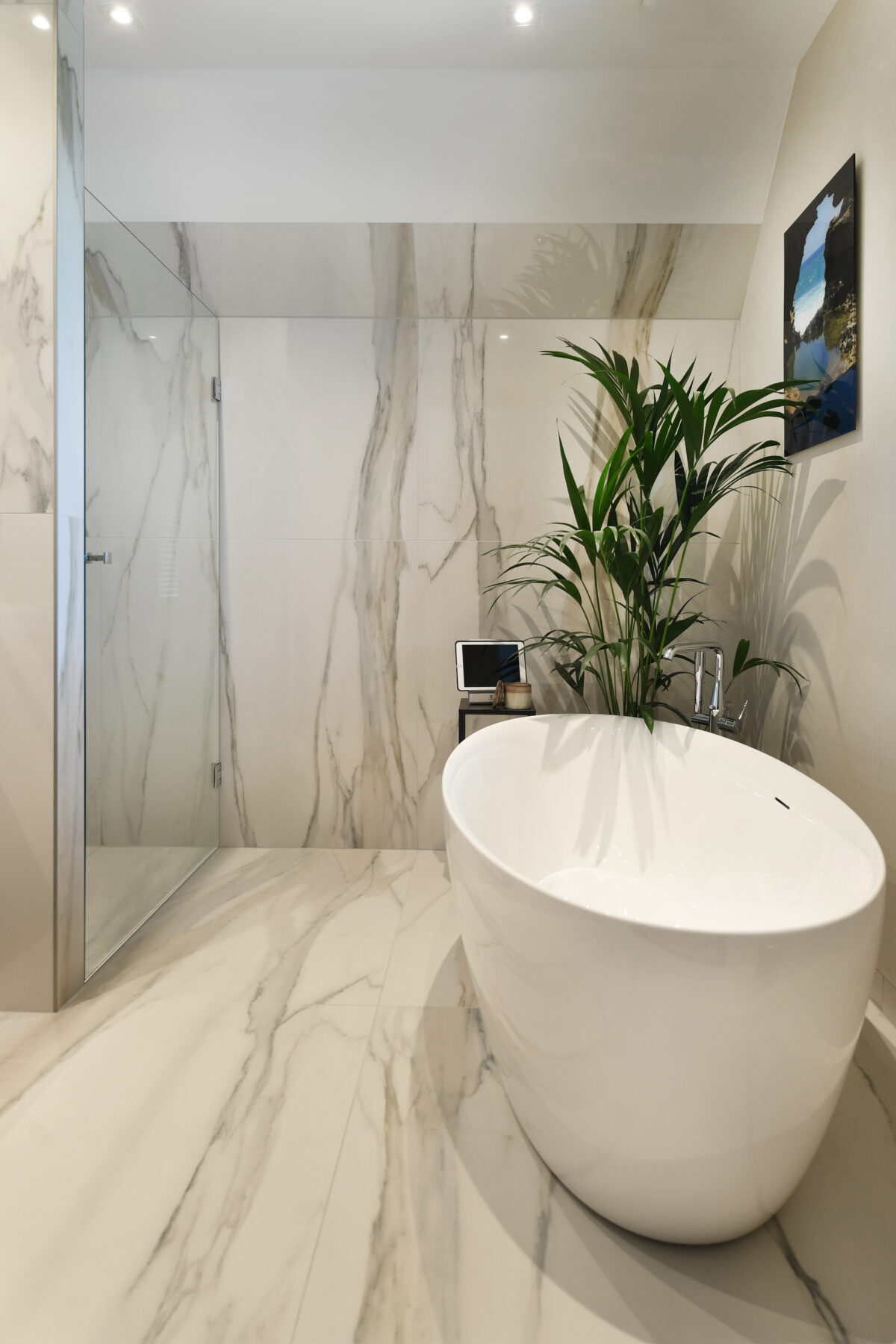 Luxe badkamer met vrijstaand bad, marmerlook wandtegels en hoogwaardige afwerking