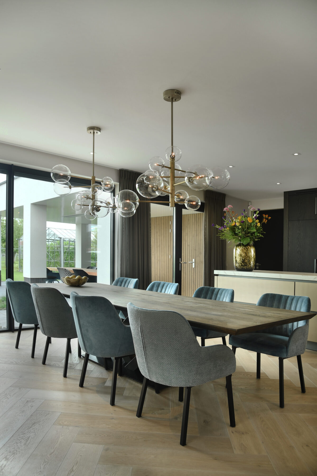Luxe eethoek met houten eettafel, design verlichting en comfortabele eetkamerstoelen