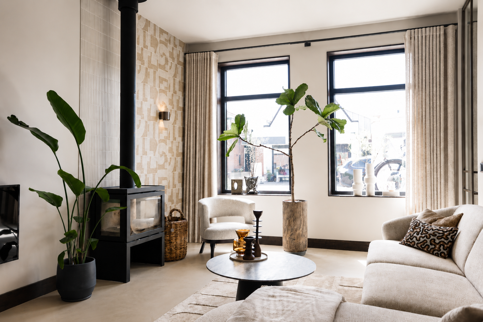 Luxe woonkamer met houtkachel, grote ramen en designmeubels in vrijstaande woning Schipluiden
